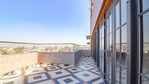 Terraza en la azotea con piso estampado, ventanas amplias y vista panorámica de la ciudad.