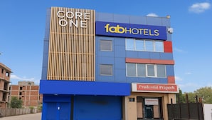 A multi-story building with a blue facade, a Core One sign, and a FabHotels sign. - Fabhotel F9 Sector 58 (Noida)