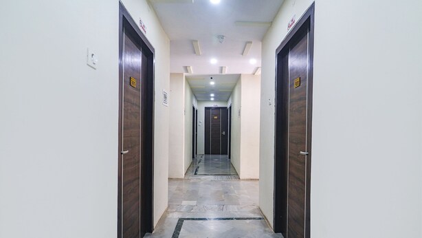 A corridor with wooden doors, each marked with a number. - Fabhotel Lotus Park (Visakhapatnam)