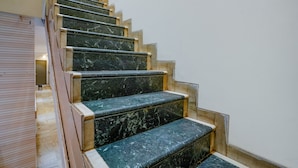 A staircase with marble steps and wooden handrails, leading to an upper floor. - Fabexpress New Deepak (Mumbai)