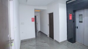Un pasillo con letrero de circuito cerrado, una puerta y un ascensor.