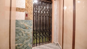 An elevator with a digital display, a patterned floor, and a decorative metal gate. - Fabhotel Prime Rockstar Suites (Kolkata)