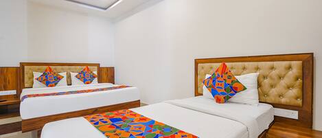 A hotel room with two beds, a ceiling fan, and a large window.