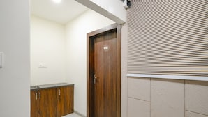 A hallway with a wooden door marked '102', a tiled floor, and a window with blinds.