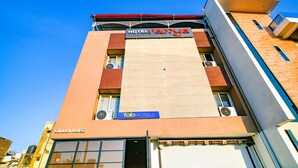 A hotel named Ramya with a modern facade, a visible air conditioning unit, and a closed shop sign.