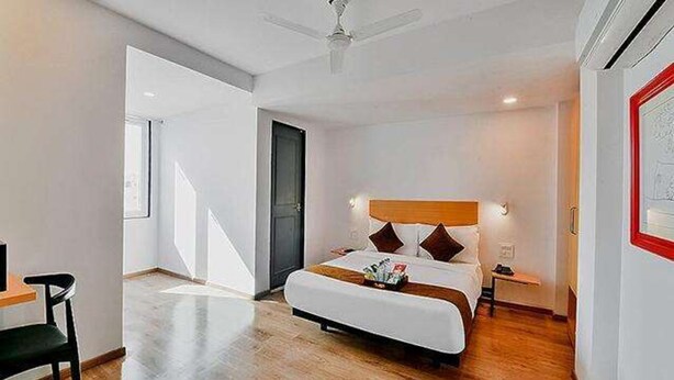 A modern hotel room with a large bed, a desk, and a chair. - Fabhotel Lupin International (Udaipur)