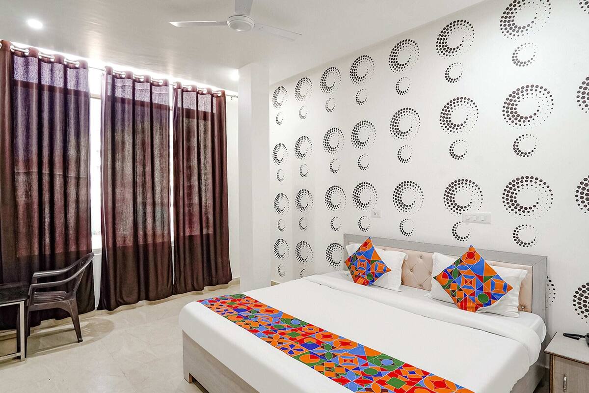 Una habitación de hotel con cama, escritorio y cortinas.