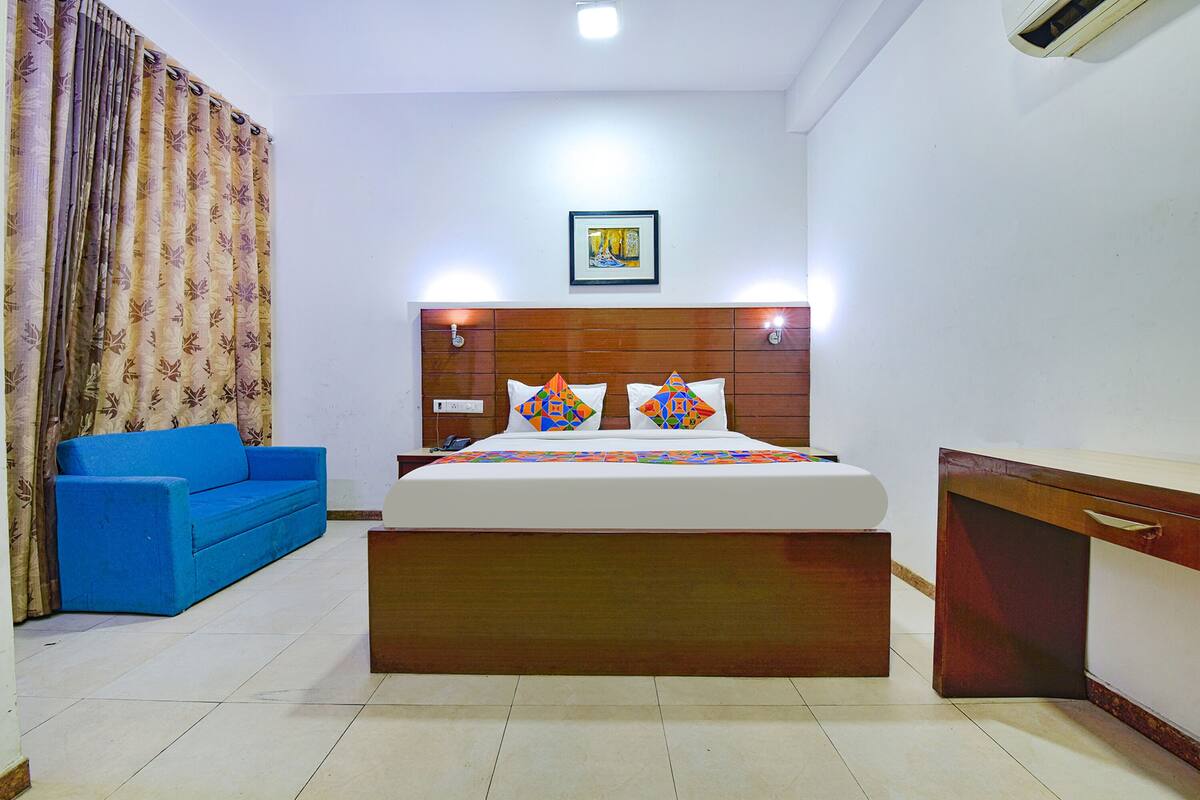 Une chambre à coucher avec une tête de lit en bois, un canapé bleu et une table de chevet.