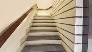 Un escalier avec une rampe en bois et des marches de couleur beige aux bords foncés.