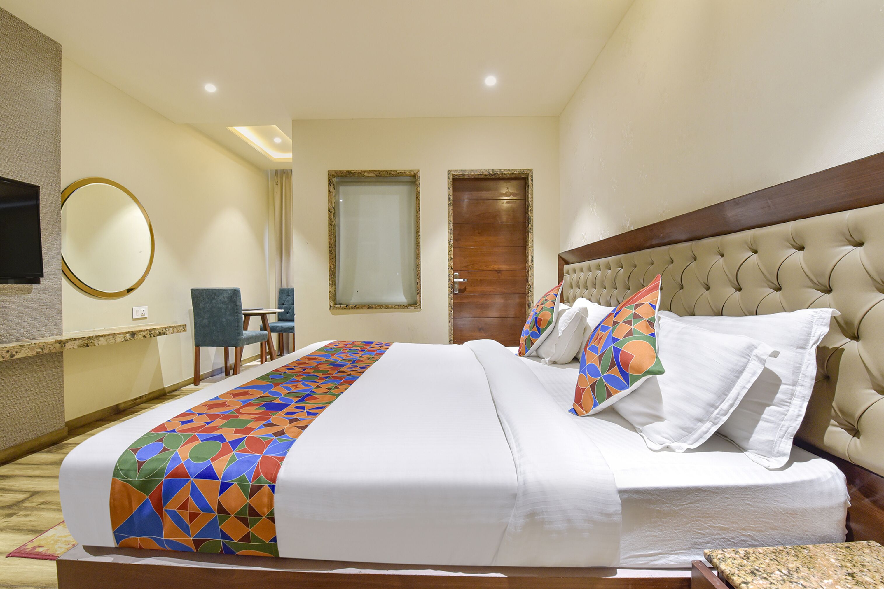 Une chambre d’hôtel avec un grand lit, une télévision, un bureau et une chaise.