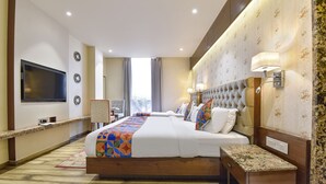 Une chambre d’hôtel avec un grand lit, une télévision, un bureau et une vue sur l’extérieur.