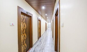 Un pasillo con puertas de madera y suelo de mármol.