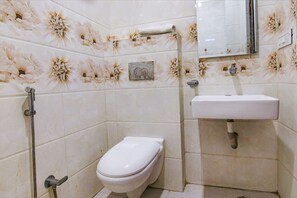A bathroom with a toilet, a sink, and a shower. - Fabhotel Legacy (Chandigarh)