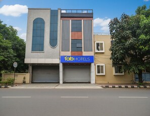 A modern building with a 'Tab Hotels' sign, large windows, and a garage door. - Fabhotel Elite Residency (Indore)