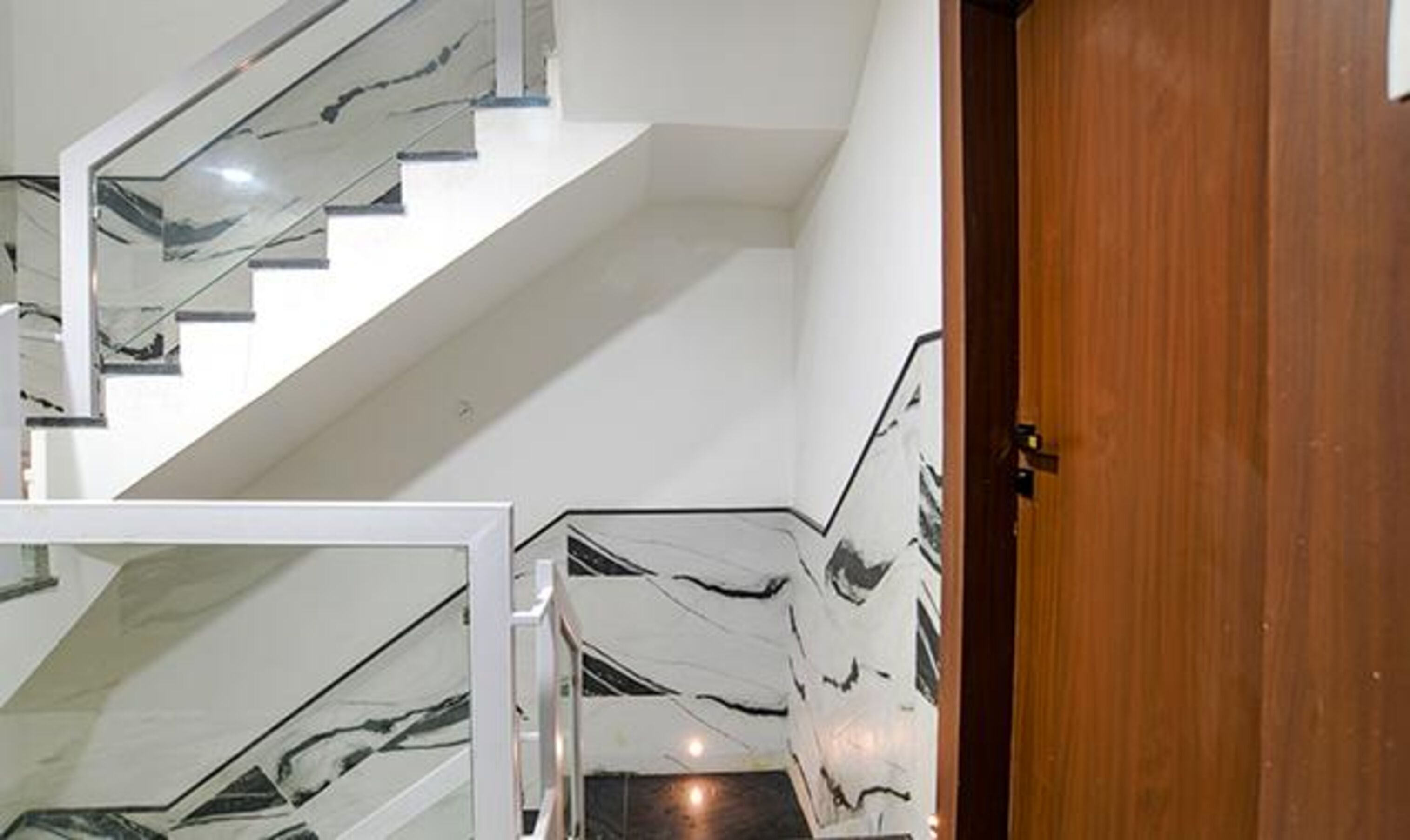 Eine Treppe mit weißen Wänden und einer Holztür.