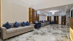 A modern hotel lobby with a beige sofa set, blue cushions, and a marble floor. - Fabhotel Elite Residency (Indore)