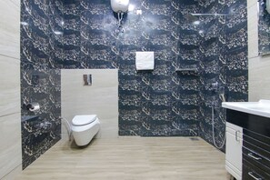 A modern bathroom with a white toilet, a shower area, and a vanity with drawers. - FabHotel Sky Lark Farm (Ludhiana)