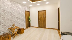Una habitación moderna con un papel tapiz de diseño geométrico, suelo de madera y dos puertas de madera.