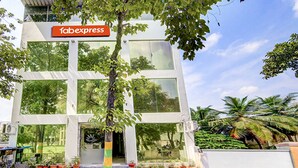 A modern building with a 'Fabexpress' sign, large windows, and a tree in front. - FabExpress Alacia Inn (Lucknow)