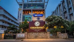 A building with multiple hotel signs including 'CHRISTOTEL', 'fabHOTELS', and 'Coastahut'. - FabHotel Chris - Whitefield near KTPO & ITPL (Bengaluru)