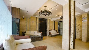 A spacious lobby with a modern chandelier, leather sofas, a coffee table, and a large mirror. - FabHotel Prime Supreme Grande 600 Mtrs away from Calangute beach (Calangute)
