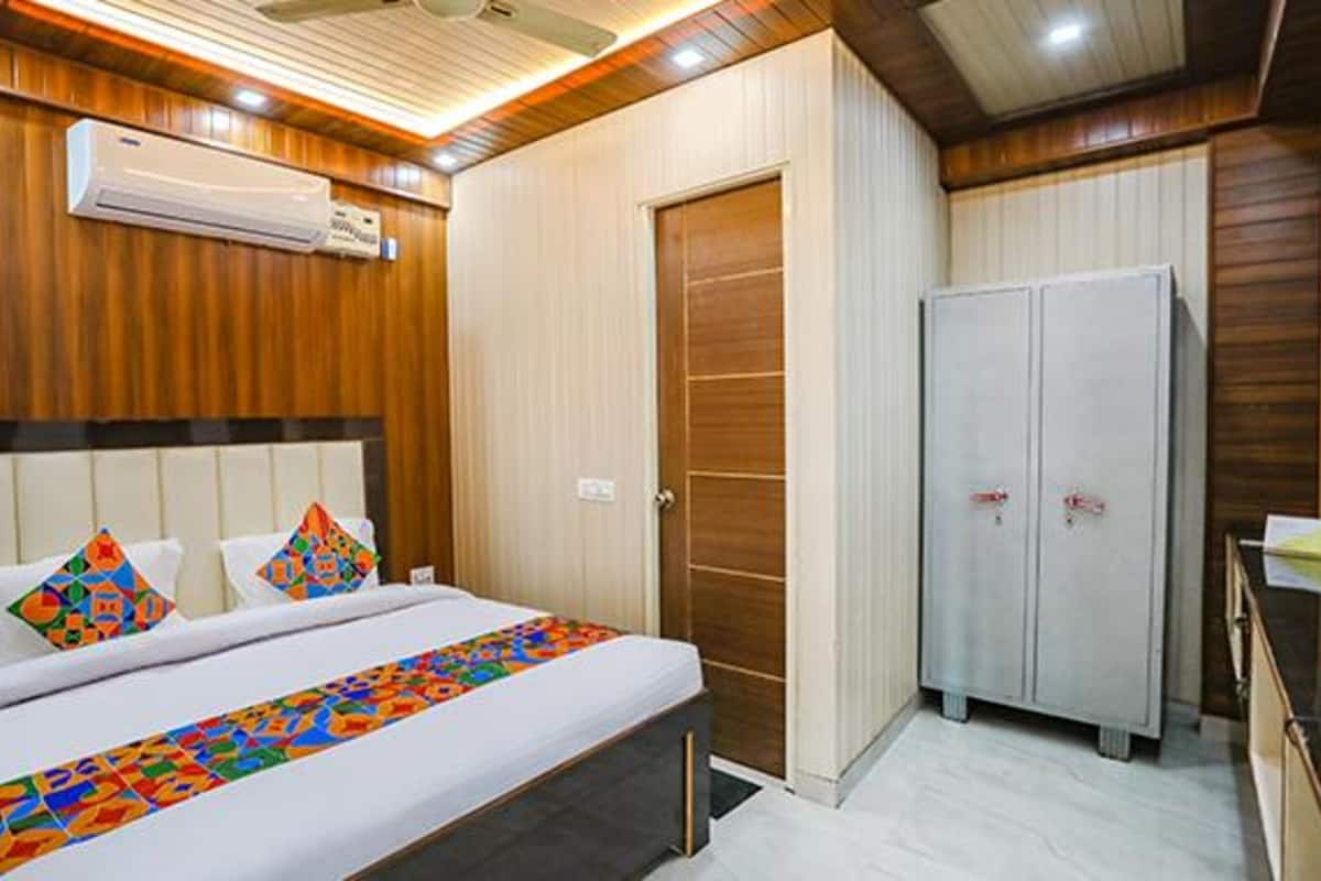 Una habitación de hotel con cama, armario y aire acondicionado.
