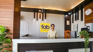 Una recepción de hotel con diseño moderno, un reloj y un cartel que dice 'fab hotels'.