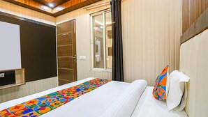 Una habitación de hotel con una cama, una ventana, una puerta y un televisor en la pared.