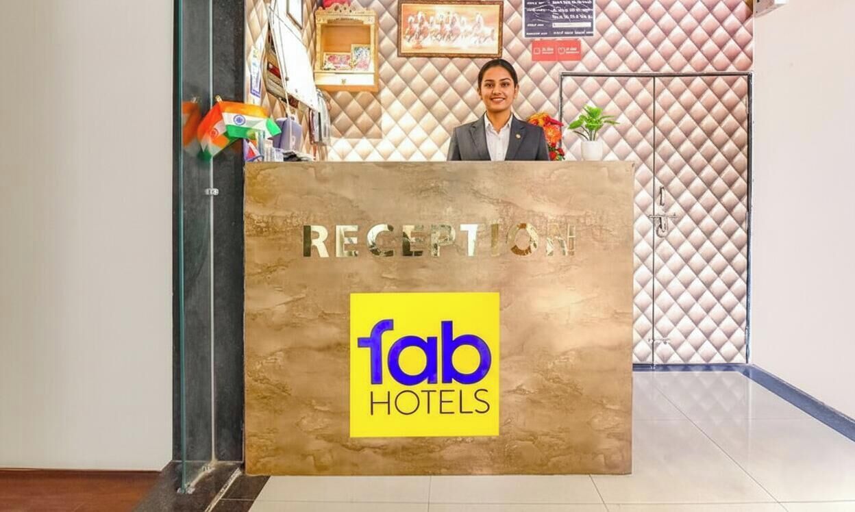 En receptionsdisk med en skylt som visar texten ”RECEPTION” och logotypen för ”fab hotels”.