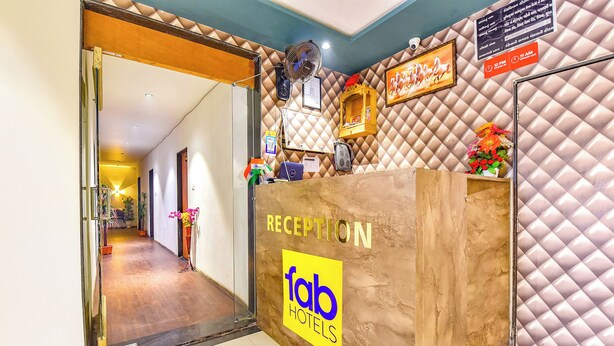 Una recepción con un cartel de 'fab hotels', un reloj y una cámara de seguridad en la pared.
