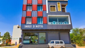 Un hotel a più piani con facciata moderna, caratterizzato da un'insegna ben visibile 'Shree Ji Hotel' e il logo 'Fab Hotels'.