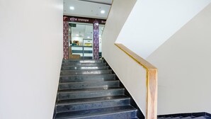 A staircase with a handrail and a patterned column. - Fabexpress Rajmahal (Navi Mumbai)