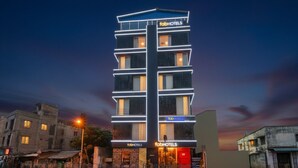 Een modern meerlaags hotel met een opvallend ‘fabHOTELS’ bord, met een strakke gevel en diverse balkons.