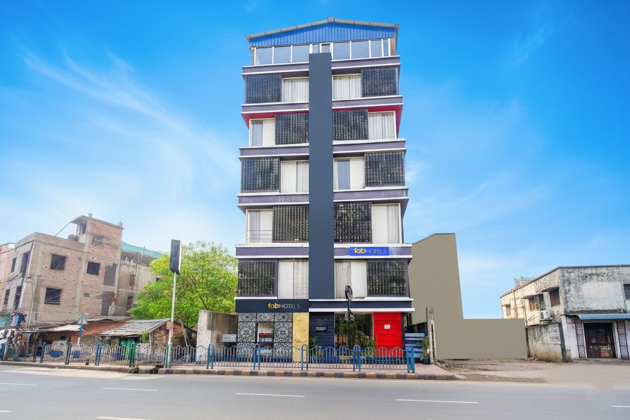 A multi-story building with a modern design, featuring a prominent vertical structure and a facade with various windows and signage.