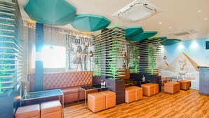 Een modern interieur met een zithoek, houten vloeren en decoratieve groene accenten.