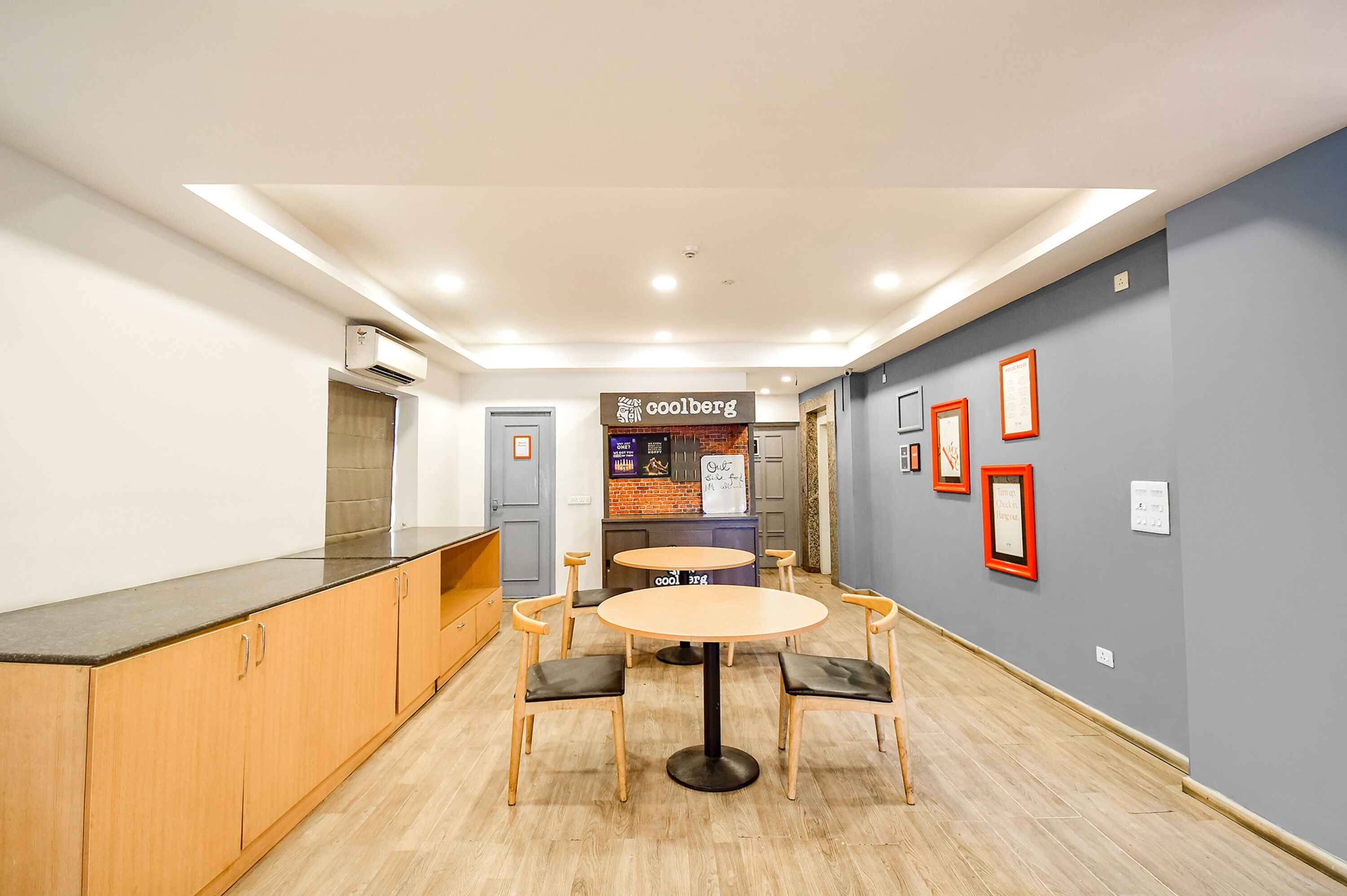A modern interior with a round table and chairs, a kitchenette, and a counter.