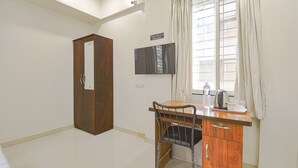 A room with a wooden desk, a chair, a television, and a wardrobe. - Fabhotel Skylight Studio Rooms (Pune)