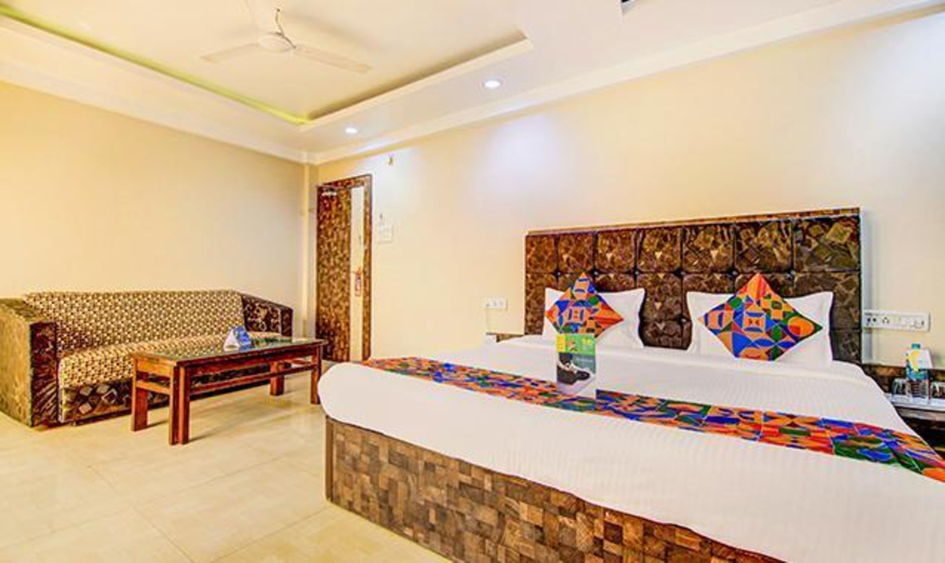 Habitación de hotel con una cama grande, un sofá, una mesita y una pared de acento de piedra.