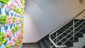 Eine Treppe mit Metallgeländer und einer Wand mit Topfpflanzen.