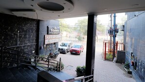 Blick vom Eingang eines Gebäudes auf eine Straße mit einem Schild für das Restaurant 'Taste of China'.