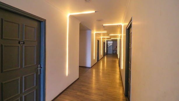 Ein Flur mit Holzboden und moderner Beleuchtung.