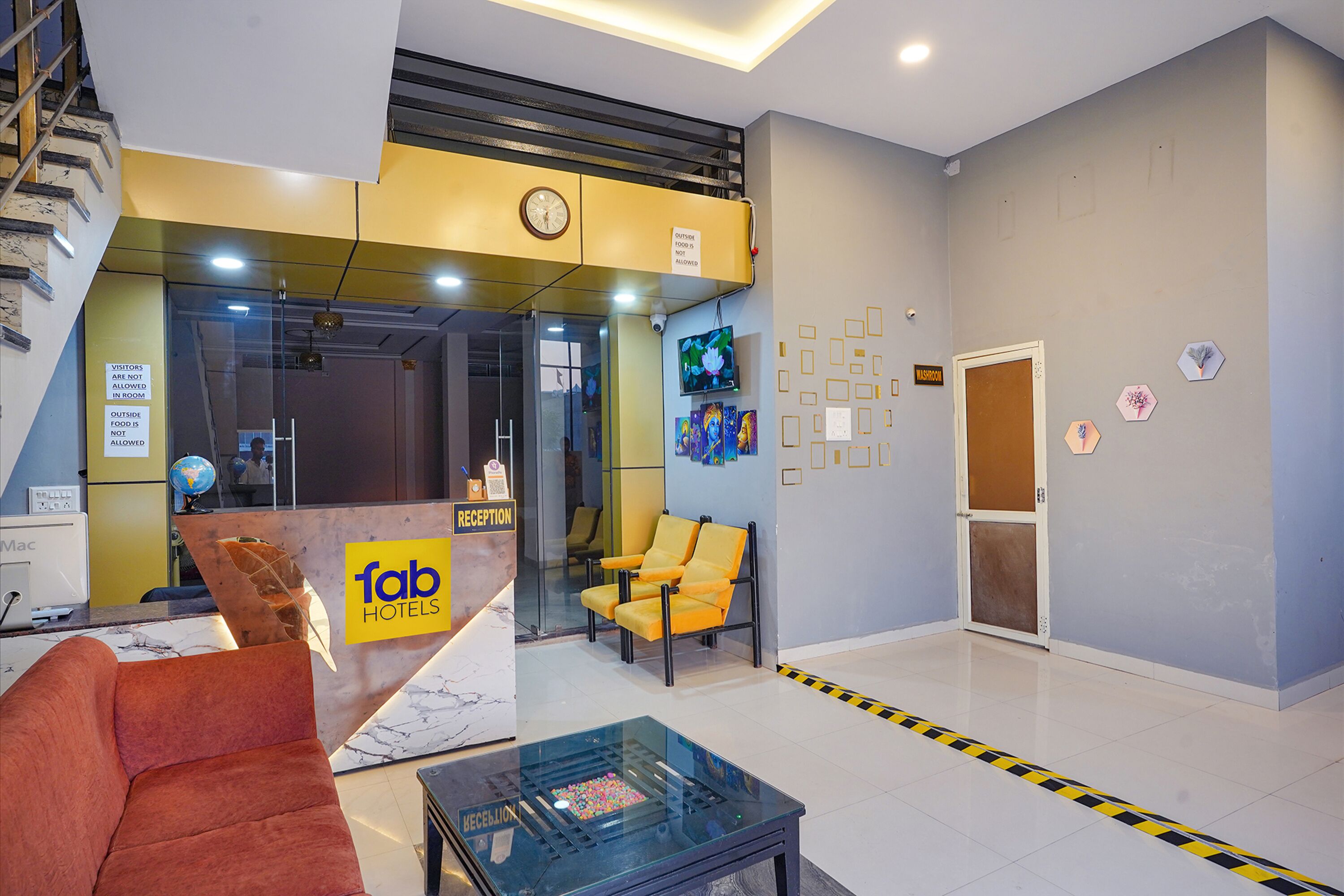 A hotel reception area with a reception desk, seating, and a clock.