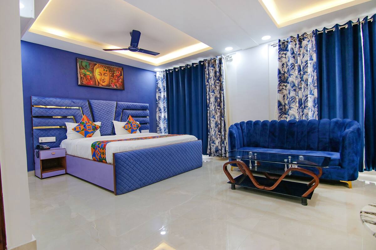 Un dormitorio moderno con cama, sofá, mesita de noche y ventilador de techo.
