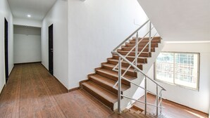 A staircase with wooden steps and metal railings, leading to an upper floor. - FabHotel Red Velvet & Suites (Pune)