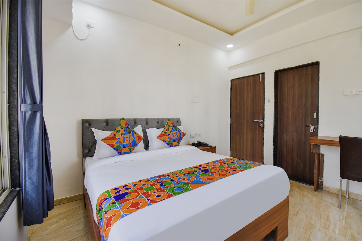 A neatly arranged bedroom with a bed, a desk, and two doors.