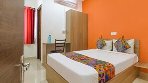 A bedroom with a bed, a desk, and a wardrobe. - Via Athidhi Stay Inn (Hyderabad)