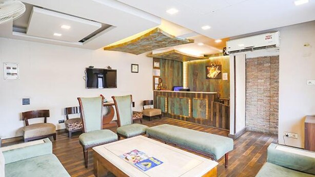 A hotel lobby with seating areas, a reception desk, and a television. - Fabhotel Clark Height (New Delhi)