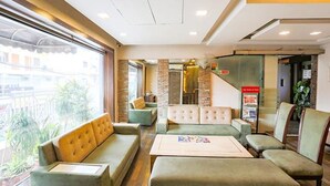 A hotel lobby with seating areas, a reception desk, and a staircase. - Fabhotel Clark Height (New Delhi)