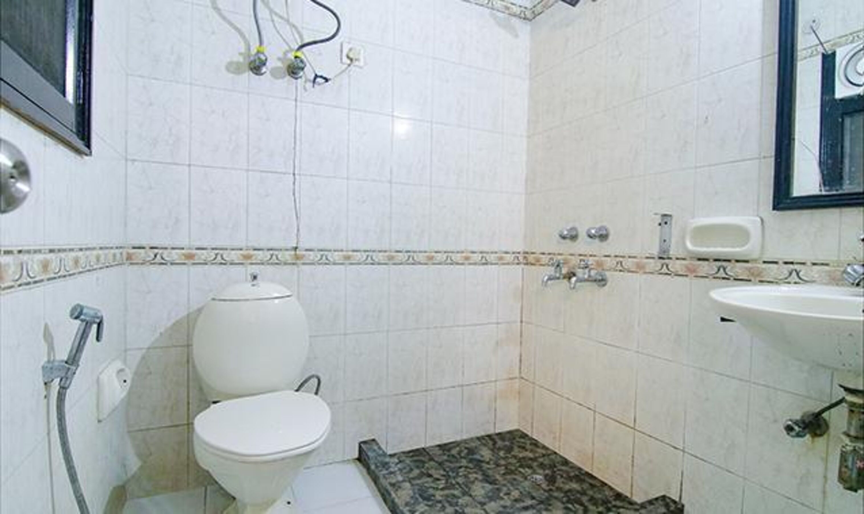 Une salle de bain avec des toilettes, un lavabo et une douche.