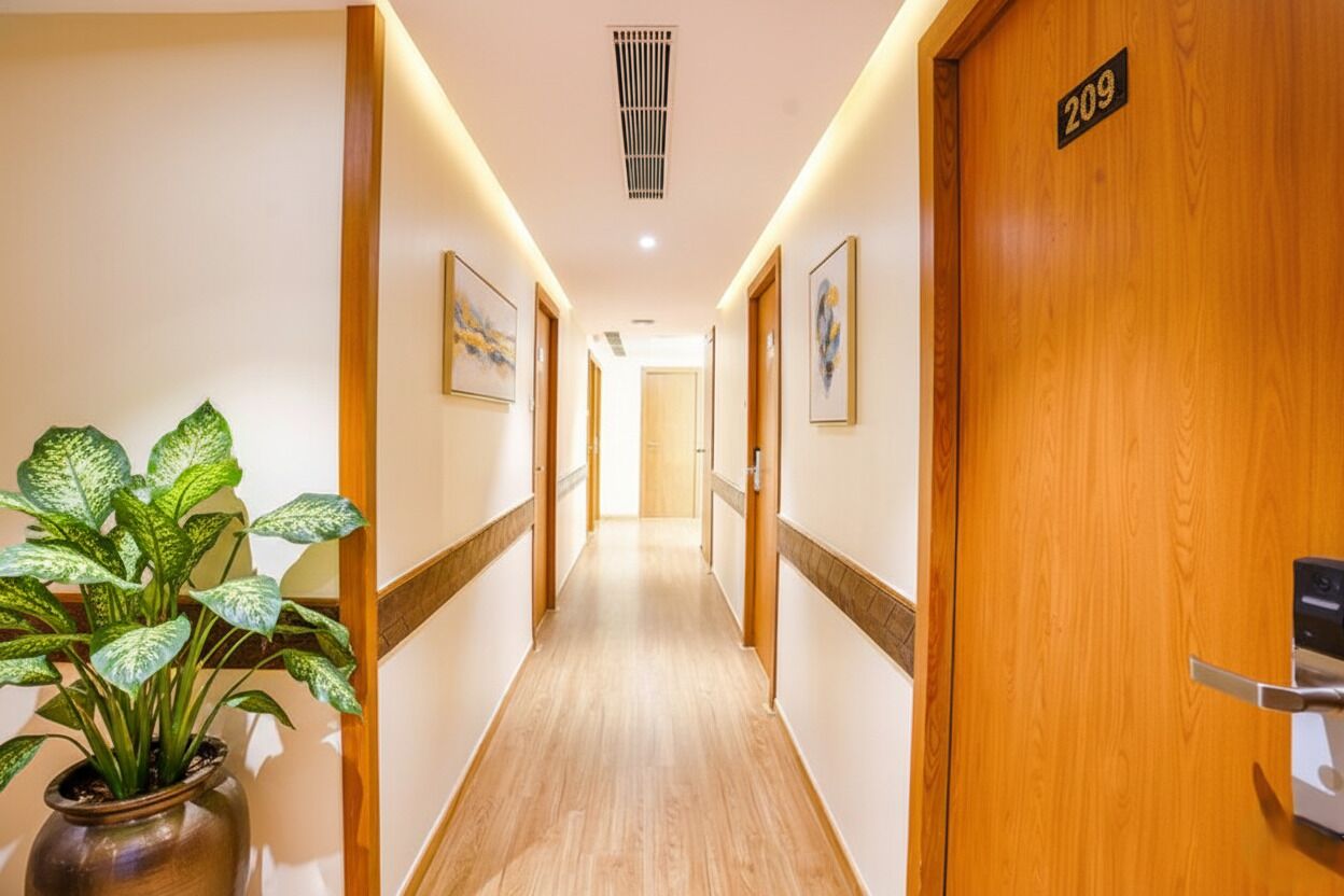 Ein Hotelgang mit Holztüren, mit der Nummer 209, und einer Topfpflanze auf der linken Seite.